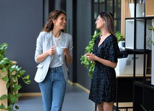 Two employees gossiping at work