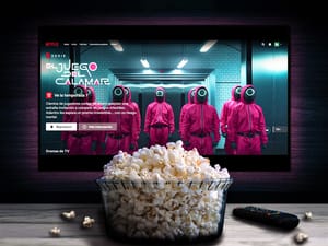 'Squid Game' main title screen on TV and a bowl of popcorn on the table