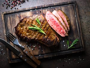 Medium rare steak on a wooden cutting board
