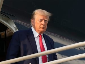 Former President Donald Trump steps off his plane as he arrives at Hartsfield-Jackson Atlanta International Airport