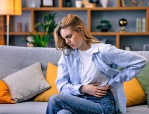 Upset woman suffering from abdominal and stomach pain