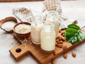 Alternative types of milk in jars on a wooden cutting board
