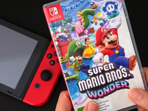  A woman holding a Super Mario Bros. Wonder game case in her hands.