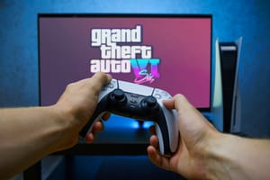 Smartphone with concept of GTA 6 logo on screen surrounded by PS5 Dualsense controllers