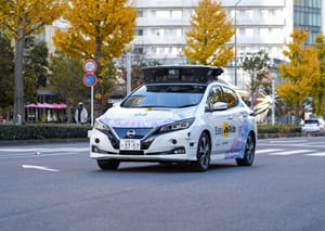 Nissan Leaf, an autonomous vehicle,  on the streets of Yokohama in front of the Nissan building.