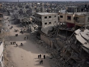 Palestinians walk through the destruction in the wake of an Israeli air and ground offensive in Khan Younis, southern Gaza Strip, Monday, April 8, 2024.