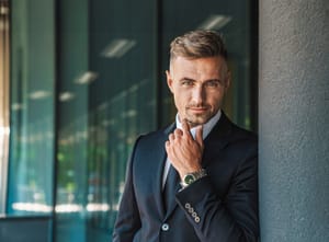A confident businessman standing outside of the office building. 
