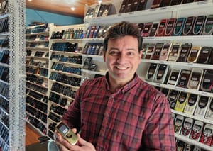 Wences Palau Fernandez smiling in a room filled with shelves of old Nokia mobile phones.