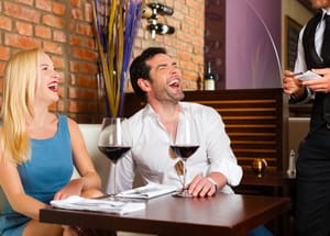 A couple laughing out loud in a restaurant.