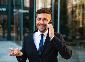 A businessman talking on his phone and smilin