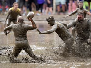 The Mudshark's Jevin Smith, center, gets around Muddas' blocker Kurt Mailloux to put pressure on quarterback Jay Holder in a football game at the 2024 Mud Bowl Sunday, Sept. 8, 2024, in North Conway, N.H.
