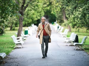 A man in a raincoat walking in the park
