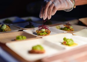 Olga Leon garnishes tostadas made with "lab-grown" chicken at a pop-up tasting hosted by California-based producer Upside Foods, Thursday, June 27, 2024, in Miami.