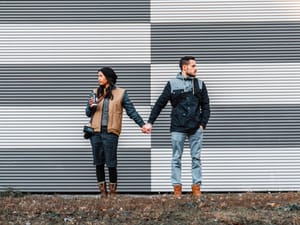 A couple holding hands while looking in the opposite directions