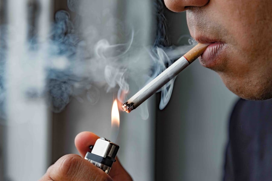 smoke a cigarette in japanese woman smoking at a Tokyo bus shelter Stock Photo What Are Japan's Smoking Etiquette