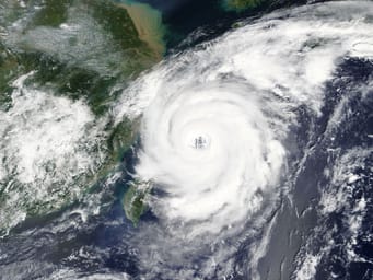 Typhoon Talim approaching China and Taiwan, with satellite imagery provided by NASA illustrating the storm's massive size and swirling clouds.