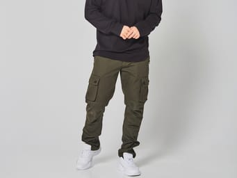 A model wearing cargo pants in military green color.