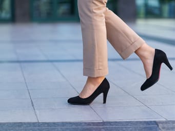 A woman wearing classic black high heel shoes.