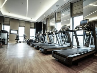 The interior of a fitness club in a luxury hotel, features modern equipment, sleek design, and ample space for guests to exercise and relax.