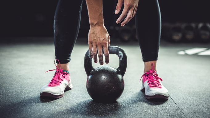 A closeup of a woman lifting a kettlebell