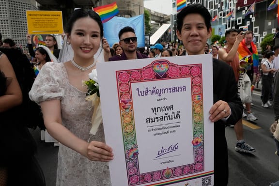 Participants hold posters celebrating equality in marriage during the Pride Parade in Bangkok, Thailand, Saturday, June 1, 2024.